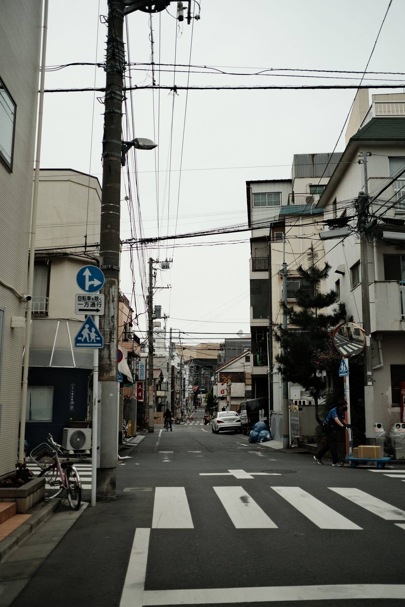 Neighborhood Crossing — Signs point the way down a low-slung street.